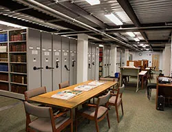 The stacks of the library's storage unit in Hoge with a table in the foreground.